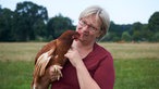 Bärbel Bird mit einem Huhn auf dem Arm. 