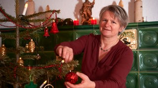 Brigitte Müllerleile schmückt einen Weihnachtsbaum.