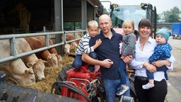 Claudia Keil mit ihrem Mann und den drei Kindern vor dem Kuhstall.