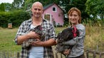 Dunja und Stefan mit Hühnern auf dem Arm