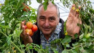 Gregor Keller inmitten von roten Tomaten