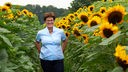Helga Trimborn in einem Sonnenblumenfeld.