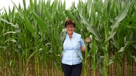 Helga Trimborn steht in einem Maisfeld
