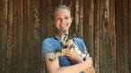 Katja mit Ziegenbaby im Arm