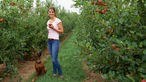 Lea Unterhansberg mit Hund Heidi in der Apfelplantage. 
