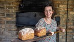 Nicole Nassiry mit frisch gebackenem Brot vor dem Backofen. 