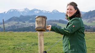 Theresa Tischner auf der Weide mit Bergpanorama im Hintergrund.