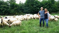 Andreas und Andrea Flötotto - im Hintergrund ihre Schafe auf der Weide.