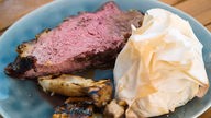 Roastbeef am Knochen vom Grill, Teigbonbons mit Rhabarber-Ziegenkäse-Nuss-Füllung und gegrillte Pilze.