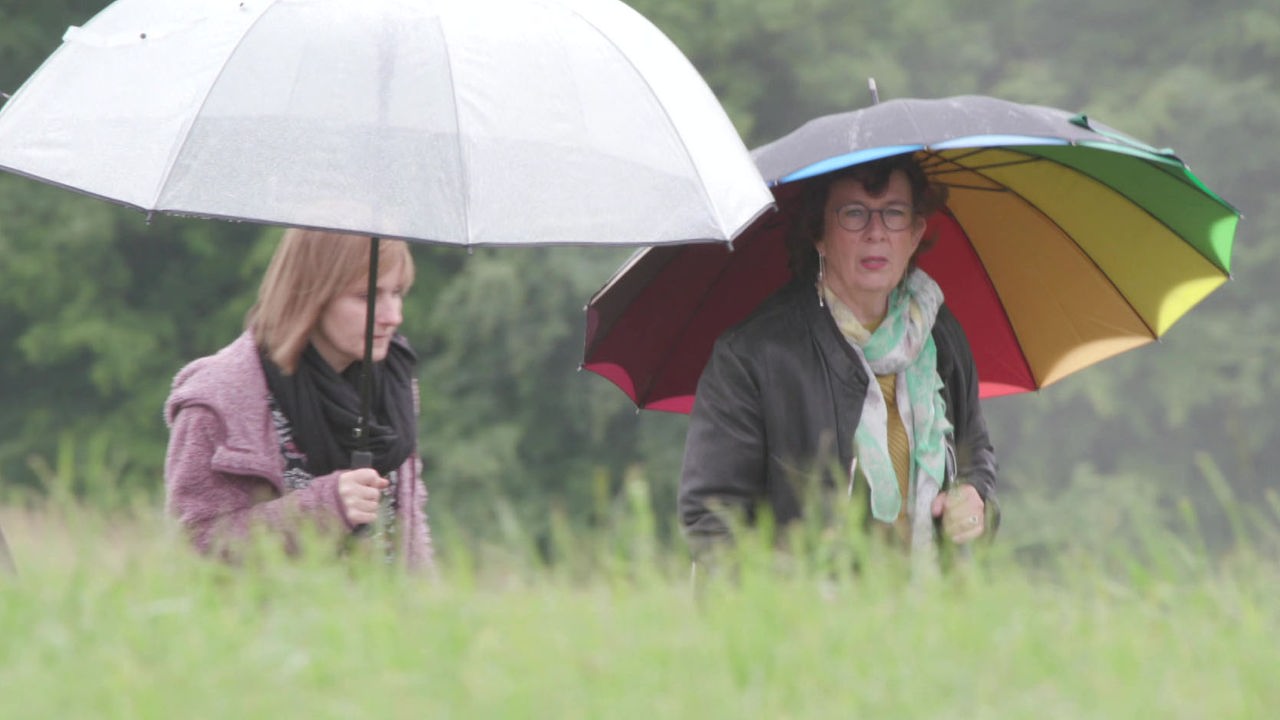 Judith Grümmer geht mit einer Kundin im Regen spazieren