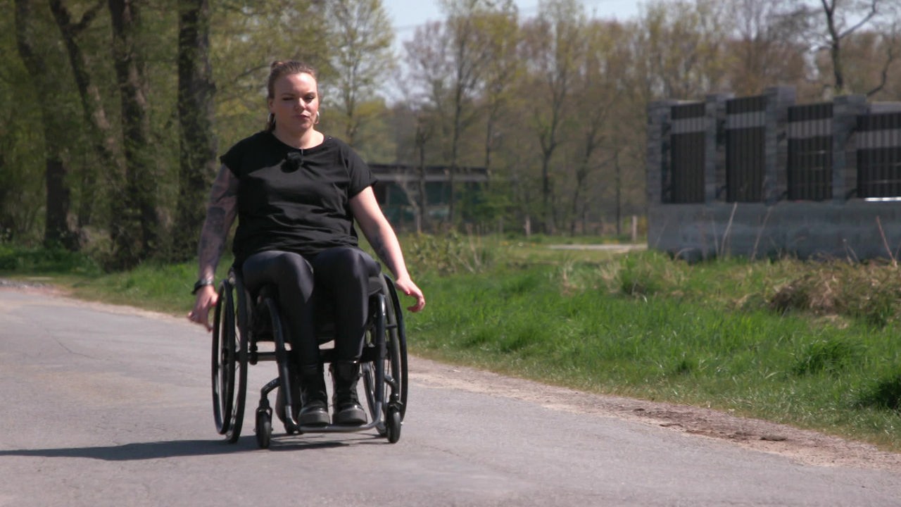 Ina Flake im Rollstuhl auf einem Weg 