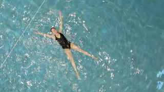 Helena Mohr lässt sich in einem Schwimmbecken im Wasser treiben