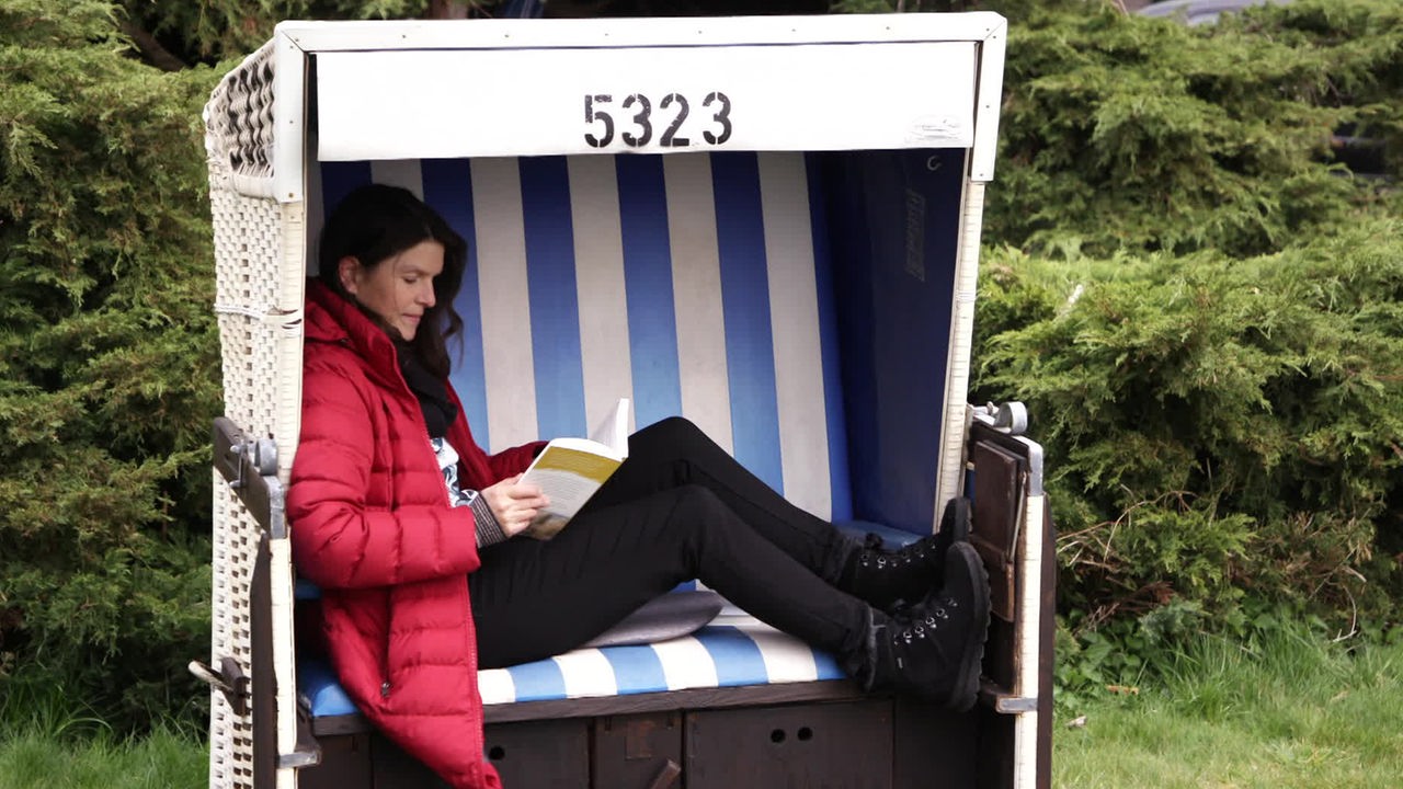 Simone Heintze sitzt in einem Strandkorb und liest ein Buch