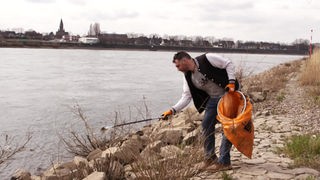 Christian Stock sammelt am Rheinufer Müll