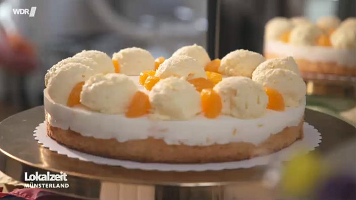 Eine Mandarinen-Joghurt-Torte mit einem Topping, das Eiskugeln ähnelt