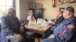 Roger Glenn und drei Verwandte sitzen an einem Tisch