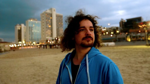 Der 20-jährige Yaar steht in TelAviv am Strand und guckt in die Ferne
