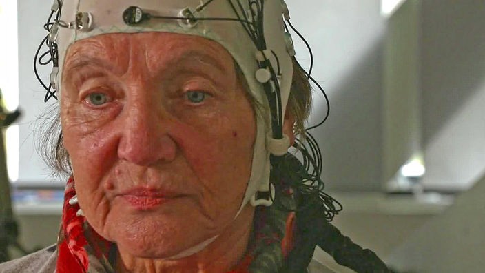 Frau unter einer EEG-Haube