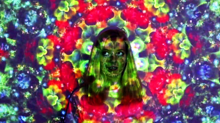 Projektion: junge Frau von floralen Motiven beleuchtet