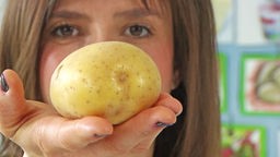 Frau mit Kartoffel auf ihrer Hand