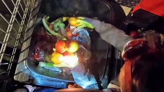 "Essensretter" an einem Lebensmittel-Müllcontainer