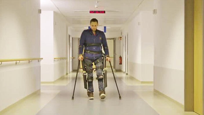 Ein Querschnittsgelähmter geht mit Hilfe eines Exoskeletts