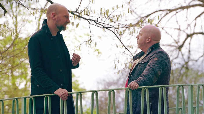 Zwei Personen auf einer Brücke