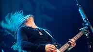 Bandmitglied von Alter Bridge wirft beim Gitarre spielen den Kopf nach hinten
