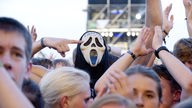 Ein Zuschauer trägt die Scream-Maske