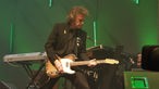Wolfgang Niedecken steht auf der grün beleuchteten Bühne und spielt auf seiner E-Gitarre