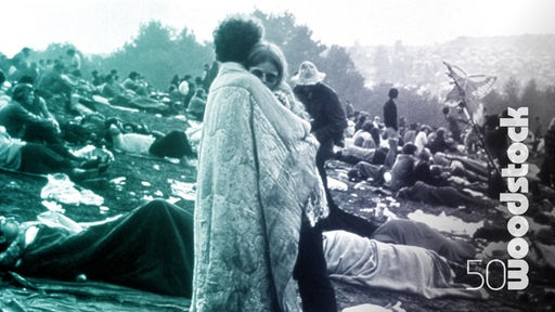 Schriftzug "woodstock 50" und Menschenmenge bei Woodstock