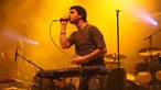 Der dunkelhaarige Mickael Karkousse von Goose singt bei der 21. Rocknacht 2007; vor ihm steht ein Keyboard der Marke Roland. 