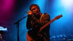 Der The Sunshine Underground-Sänger Craig Wellington umfasst mit beiden Händen das Mikrofon bei der 21. Rocknacht 2007