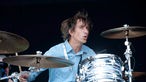 Schlagzeuger mit blaugemustertem Hemd in Bewegung