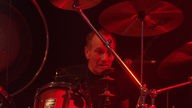 Der Schlagzeuger von "Birth-Control" im roten Bühnenlicht.