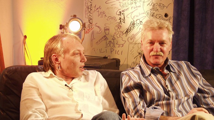Zwei Mitglieder der Band "Karthago" auf einer Couch im Interview.