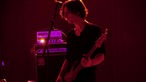 Bassist von Mark Lanegan im roten Lichtschein.