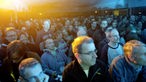 Publikum im gelb-blauen Lichtschein