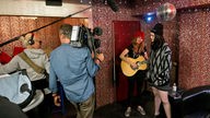 Kate Nash steht mit einer Gitarristin im Backstagebereich und spielt ein Unplugged für die Kamera des Rockpalastes.
