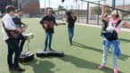Die Drei Mitglieder der Band Young Rebel Set stehen zusammen auf einem Fußball Platz und spielen ein Unplugged für die Kamera des Rockpalastes.