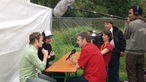 Kamerateam und zwei Männer, die interviewt werden.