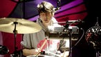  Schlagzeuger von Animal Collective mit geschlossenen Augen beim Spielen.