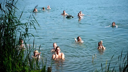 Die Besucher des Festivals kühlen sich in einem See ab