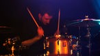 Schlagzeuger von New Desert Blues trommelt in sich gekehrt auf seinen Trommeln
