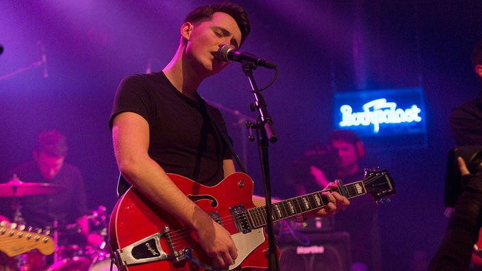 Frontmann und Gitarrist von New Desert Blues spielt lässige Akkorde und singt dabei 