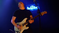 Gitarrist von New Desert Blues spielt ein heißes Solo auf seiner Fender Stratocaster E-Gitarre und legt dabei den Kopf in den Nacken