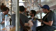 Die allerhöchste Eisenbahn spielen Unplugged in einer alten Straßenbahn, zwei Gitarren und eine Melodica, im Hintergrund der Kameramann von Rockpalast