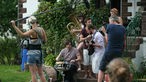 Die Band Keston Cobblers' Club sitzt auf einer Treppe und spielt unter freiem Himmel einen ihrer Songs Unplugged für das Rockpalast Team, welches die Szene Filmt