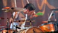 Schlagzeuger der Beatsteaks schlägt sehr enthusiastisch auf seine Trommeln ein