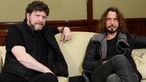 Der Bassist und der Sänger und Gitarrist der Band Soundgarden sitzen gemeinsam auf der Couch im Backstagebereich.